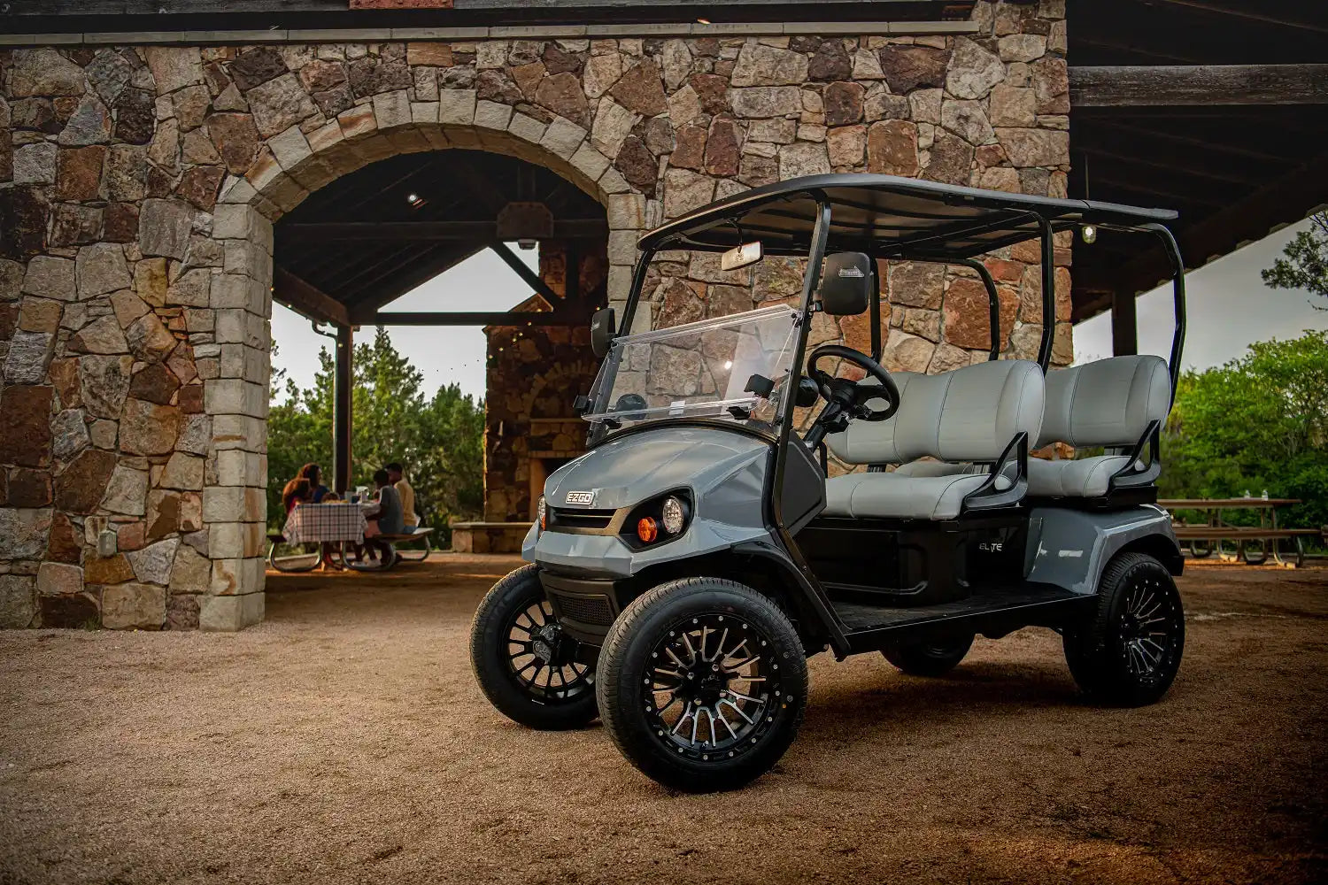 Gray golf cart with custom wheels.