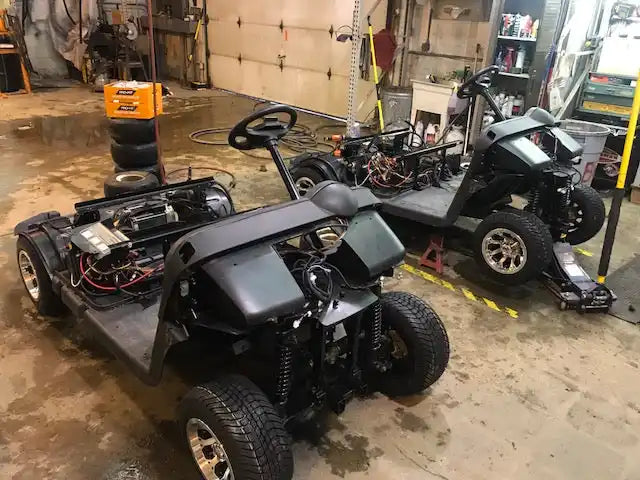 Two disassembled golf carts.