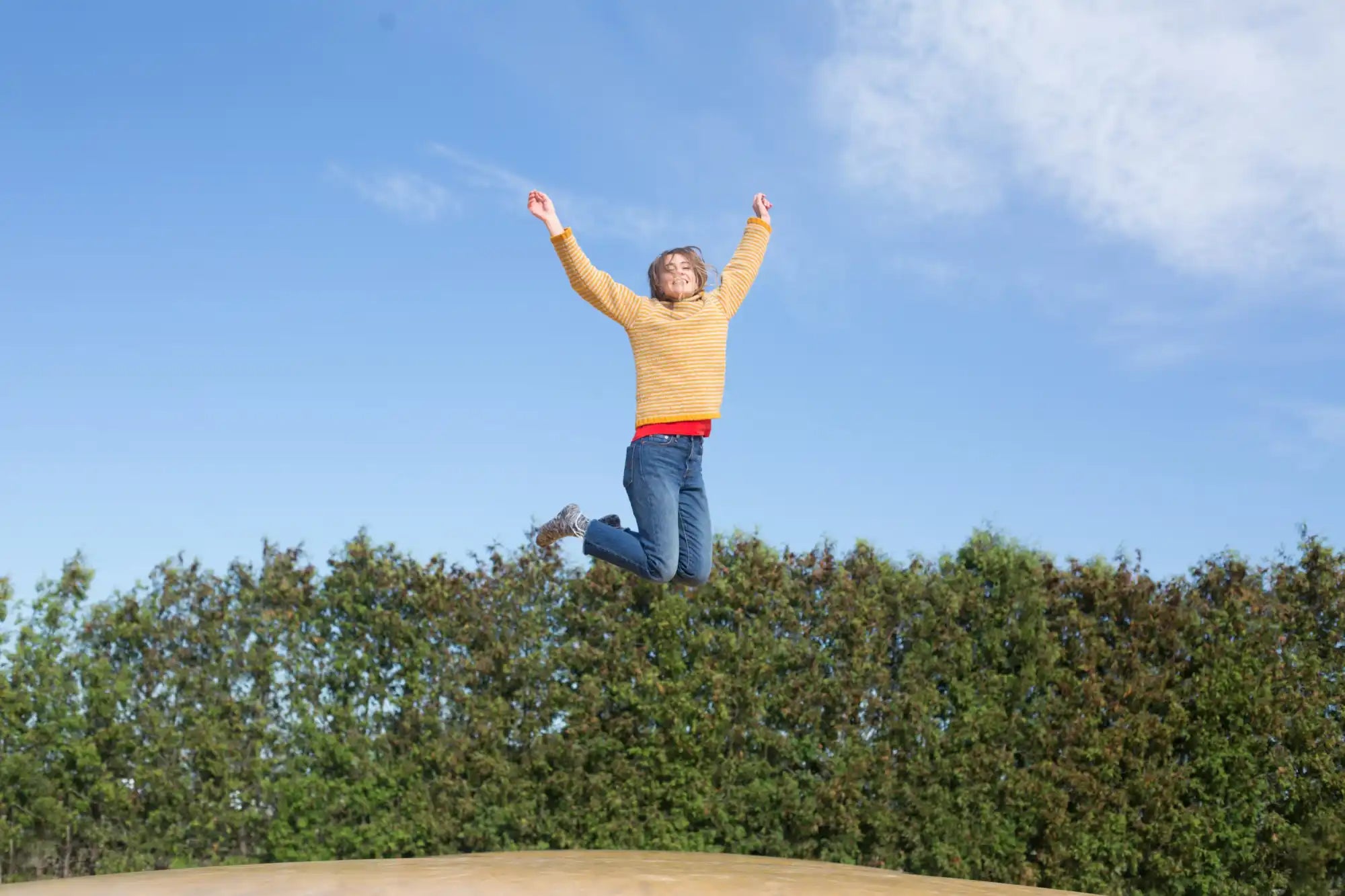 Jumping woman with arms raised.